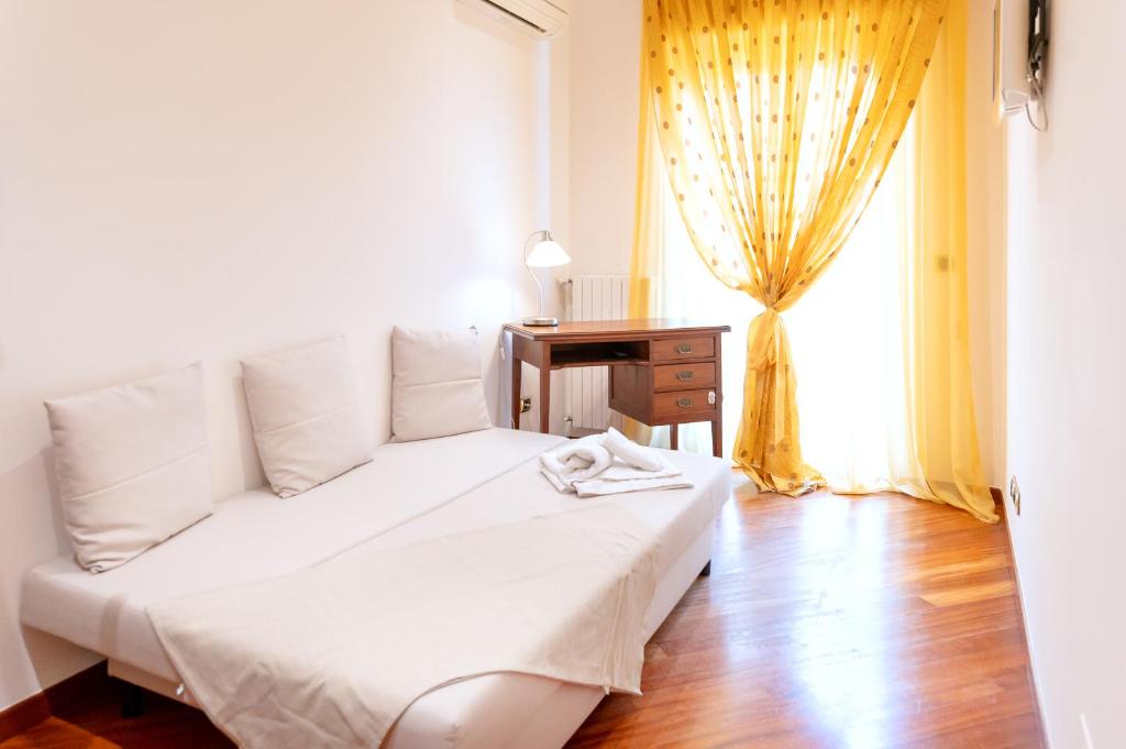 a white bed in a room with a window at Dimora: A casa di Pier in Bari