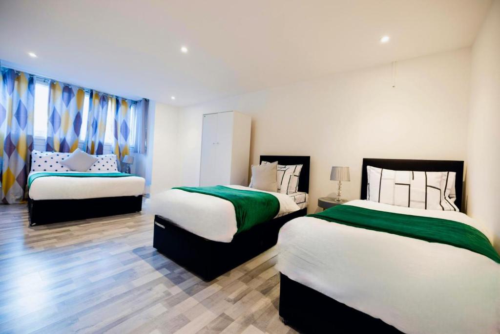 two beds in a room with two at PristineRelocation Accommodation in London