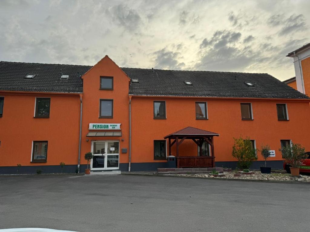 a large orange building with a white door at Pension Sachseneck in Heidenau