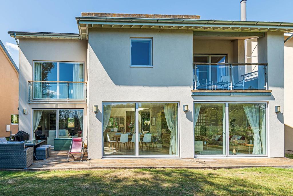 a house with large glass doors and a patio at Falcon House CW73 Lower Mill Estate Cotswolds in Somerford Keynes