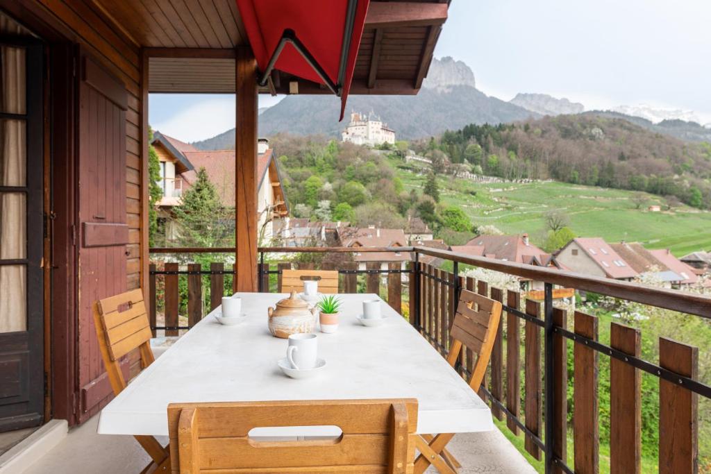 a table on a balcony with a view at Chalet de Charme avec vue spendide in Menthon-Saint-Bernard