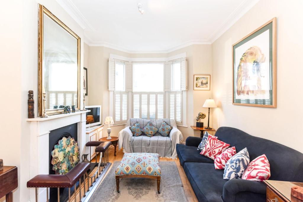 ein Wohnzimmer mit einem Sofa und einem Kamin in der Unterkunft Ivy Glendarvon Street Pro-Managed in London
