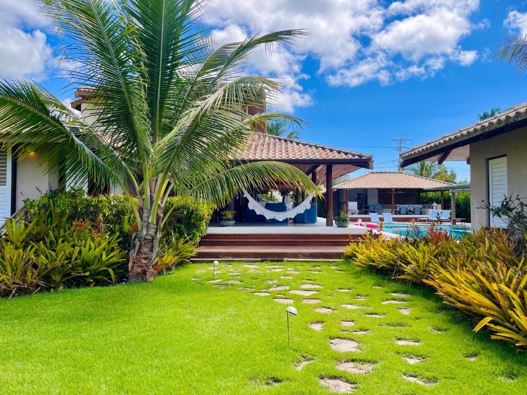 un patio con una palmera y una casa en Casa Canada Bahia en Praia do Espelho