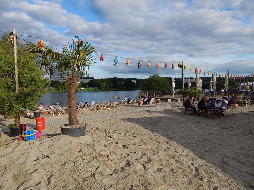 a group of people sitting on the beach near the water at Ferienwohnung Uni Koblenz in Koblenz
