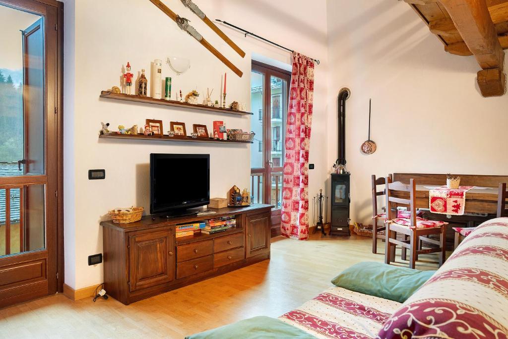 a living room with a tv on a wooden cabinet at Casa sul Fiume in Vernante