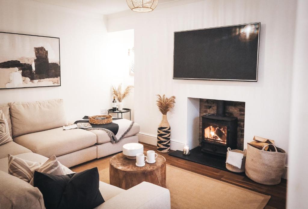 a living room with a couch and a fireplace at Pye Corner Cottage, by Solace Stays in Bellaghy