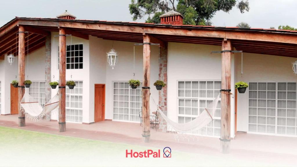 una pérgola con una hamaca fuera de una casa en Cabin Durazno Green Haven with amenities, en Zitácuaro