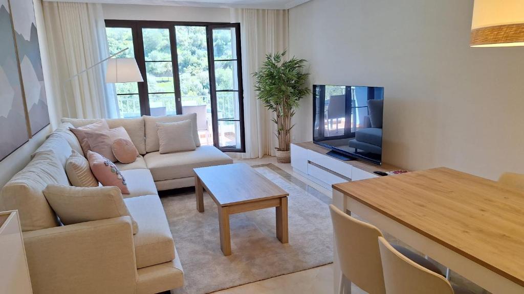 - un salon avec un canapé, une télévision et une table dans l'établissement La Torre del Paraiso, à Malaga