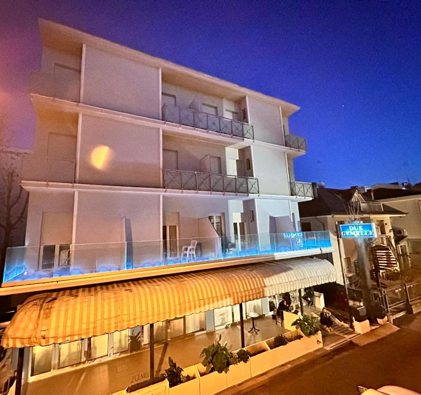 a large white building with an awning in front of it at Due Gemelle in Rimini