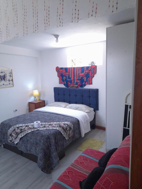een slaapkamer met een groot bed met een blauw hoofdeinde bij Apartamento sn in Puno
