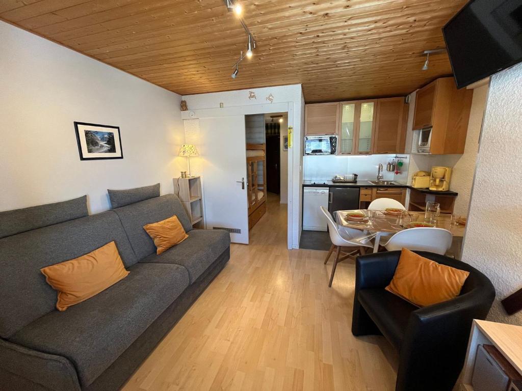 a living room with a couch and a table and a kitchen at Appartement cozy aux Gets - Ski-in/Ski-out, proche centre et commodités - FR-1-623-214 in Les Gets