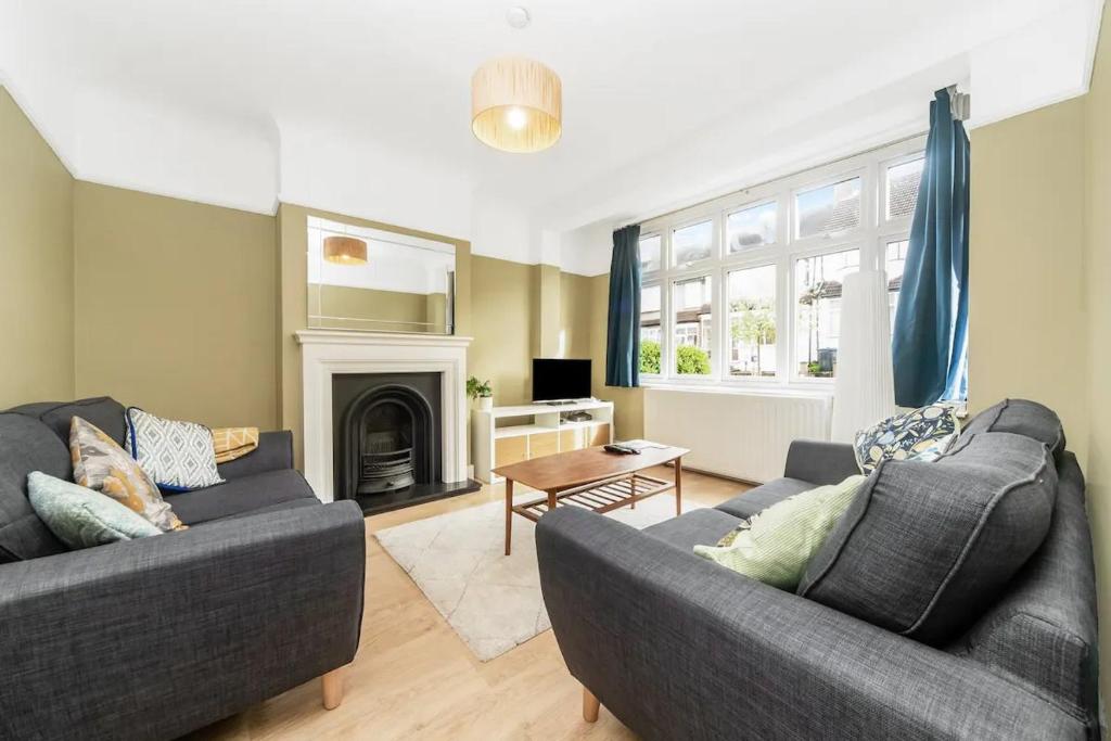 sala de estar con 2 sofás y chimenea en Pass the Keys Spacious Family Home in London, en Londres