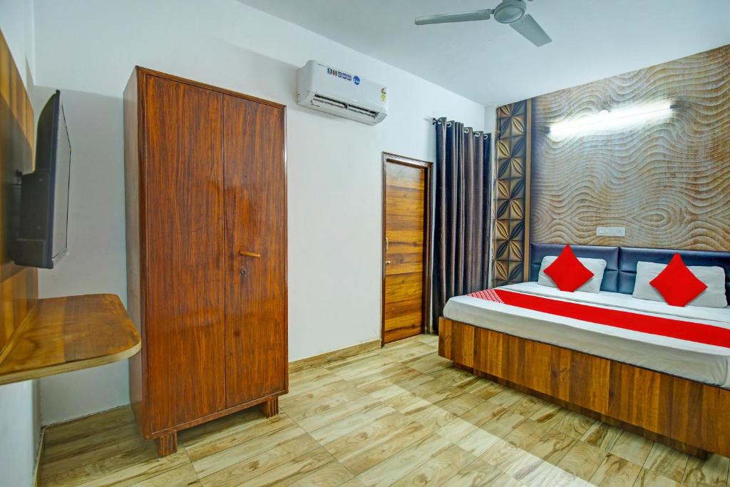 una camera da letto con un letto con cuscini rossi di OYO HOTEL WINNER INN a Ludhiana