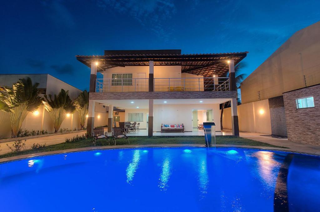 a swimming pool in front of a house at night at Casa Incrível na Praia de Tabuba by Carpediem in Cumbuco