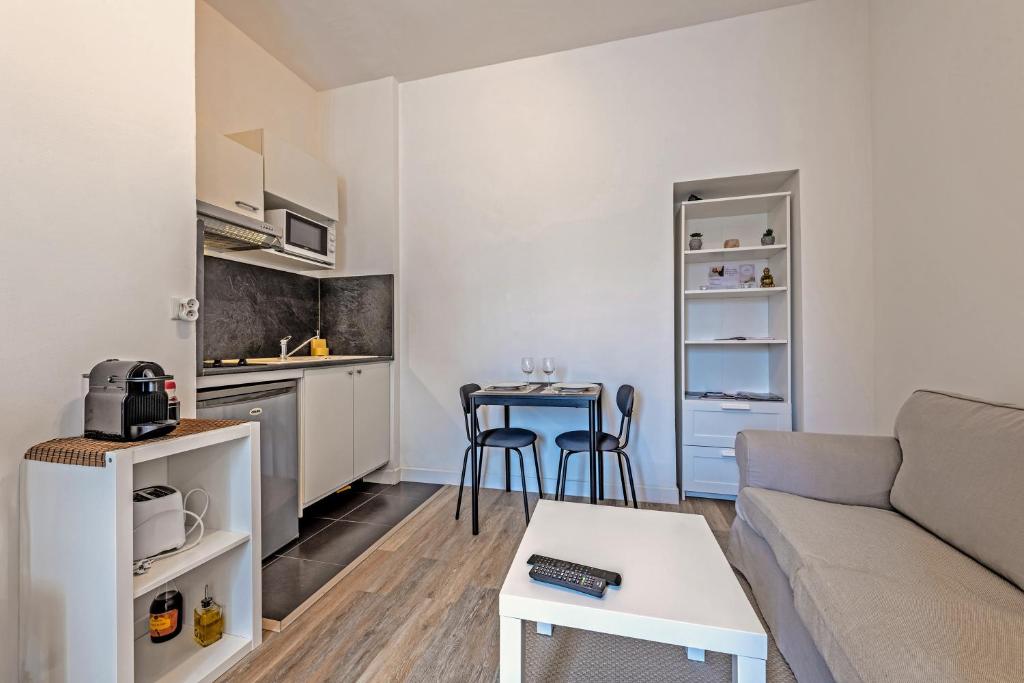 - un petit salon avec un canapé et une table dans l'établissement Les Capucins - T2 tout confort, à Brest