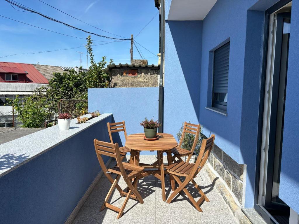 Una mesa de madera y dos sillas en un balcón. en Casa do Couteiro, en Braga
