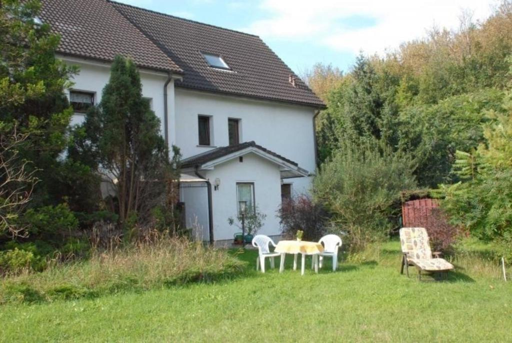 une maison avec une table et des chaises dans la cour dans l'établissement Ferienwohnung in Leuenberg mit Garten und Grill, à Werneuchen