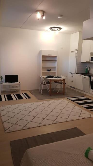 a kitchen with a table in the middle of a room at Cozy Studio in Vantaa in Vantaa