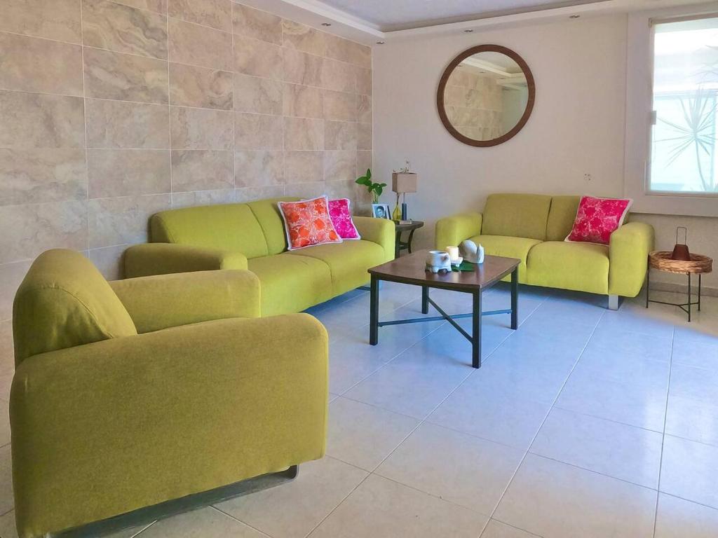a living room with two couches and a table at Casa Coccoloba, Chetumal, Quintana Roo in Chetumal