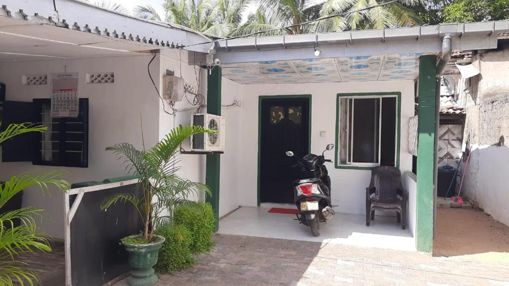 a motorcycle parked outside of a house at KANTHI GUEST INN in Trincomalee