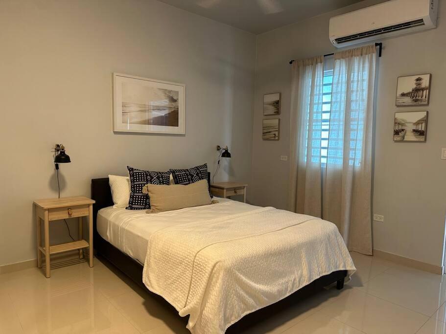 a white bedroom with a bed and a window at C&C Studio in San Juan