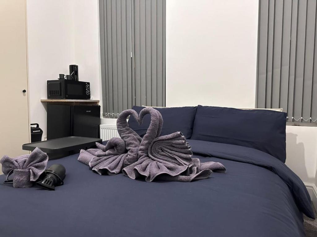 a bed with two swans wrapped in purple towels at Room in Central London Zone 1 in London