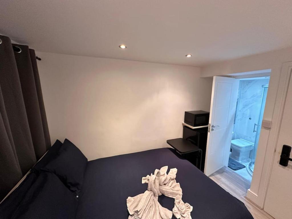 ein Schlafzimmer mit einem schwarzen Bett und ein Badezimmer in der Unterkunft Central London Zone1 Room - Bath in London