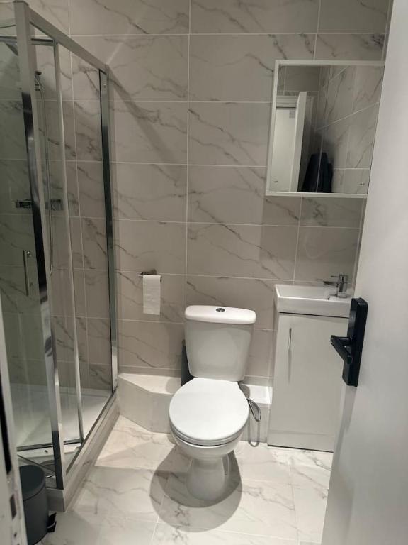 a white bathroom with a toilet and a shower at Piccadilly Circus 15minutes away in London