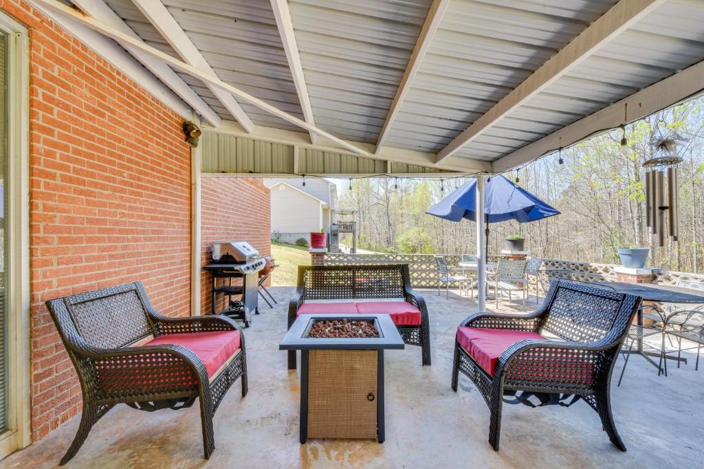 un patio con tre sedie, un tavolo e un ombrellone di Seneca Abode with Furnished Deck Less Than 10 Mi to Clemson! a Seneca