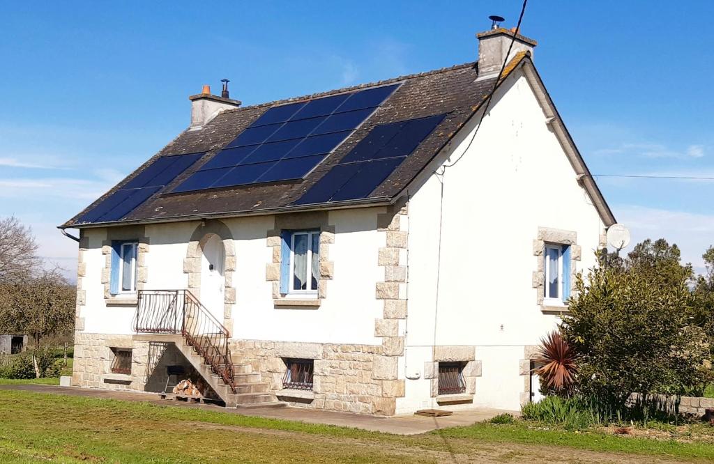 uma casa com painéis solares no telhado em Charmante maison néo-bretonne em Plumaudan