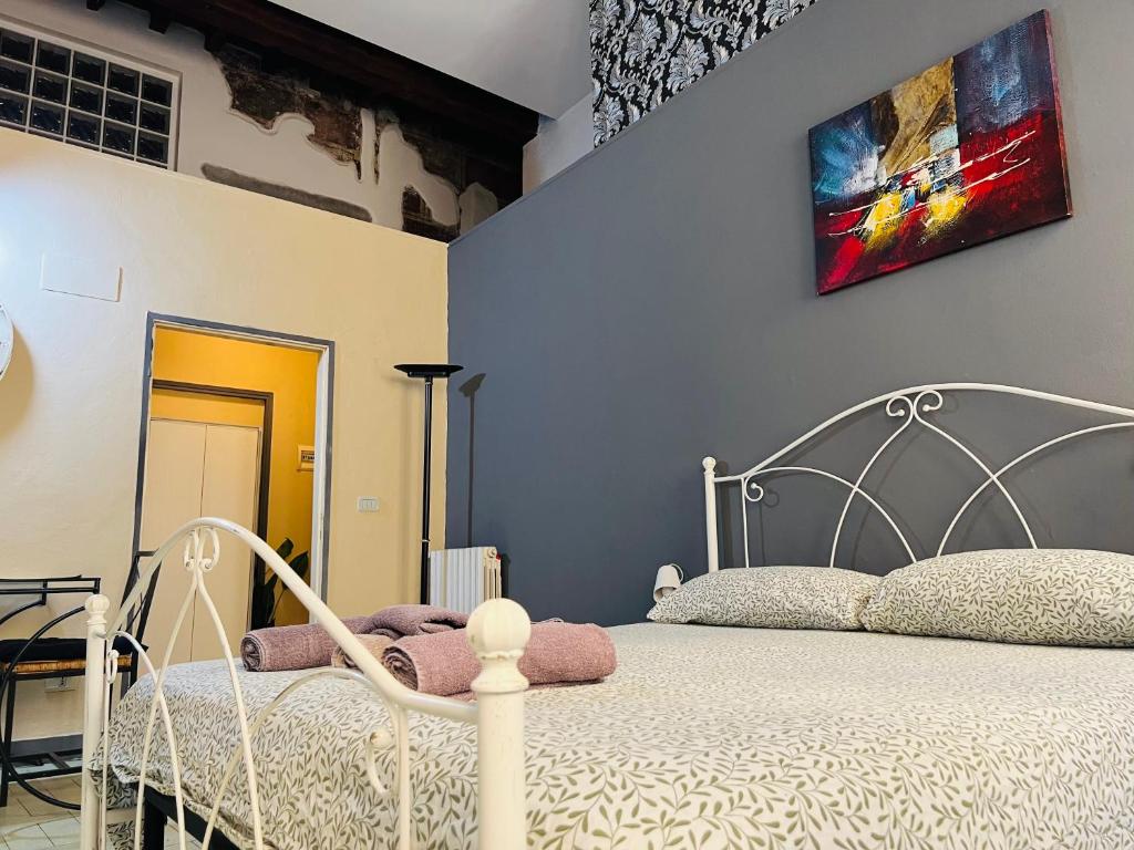 ein Schlafzimmer mit einem weißen Bett und einem Gemälde an der Wand in der Unterkunft Signoria studio apartment in Florenz