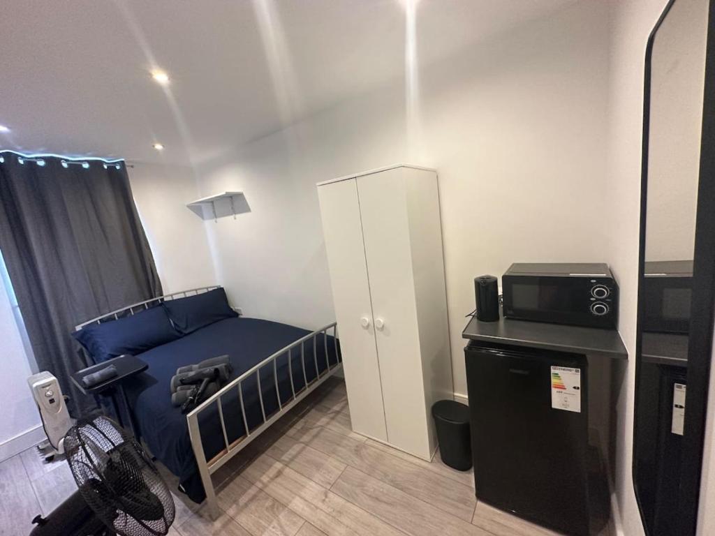 a small room with a bed and a refrigerator at Central London Zone 1 in London