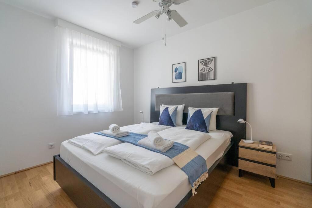 ein Schlafzimmer mit einem großen Bett mit blauen Kissen in der Unterkunft HM • Urban 1BR Retreat, Easy City Link in Wien