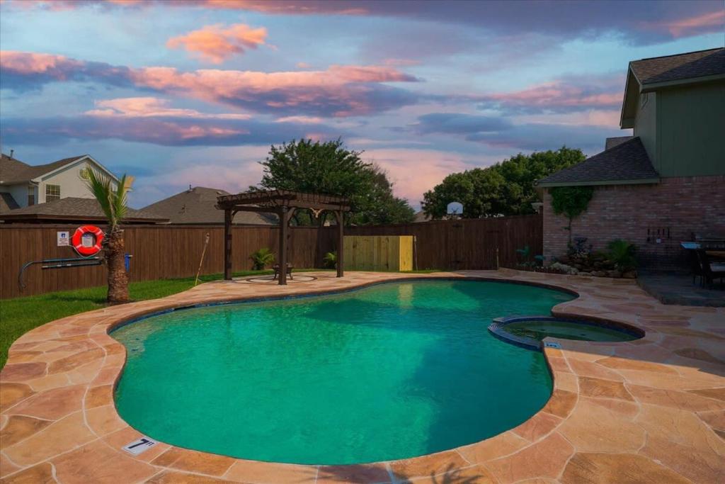 - une piscine dans une cour avec une clôture dans l'établissement Amazing Modern Spacious Home with Pool, à Rowlett