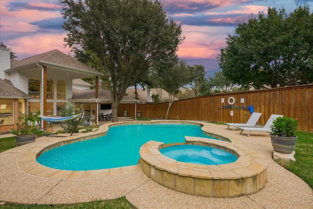 uma piscina num quintal com uma cerca de madeira em Spacious and Luxury Home w Cinema Room and Pool em Grand Prairie