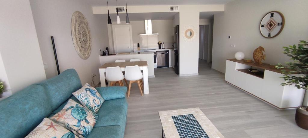 a living room with a blue couch and a kitchen at Apartamento Domara Vera in Vera