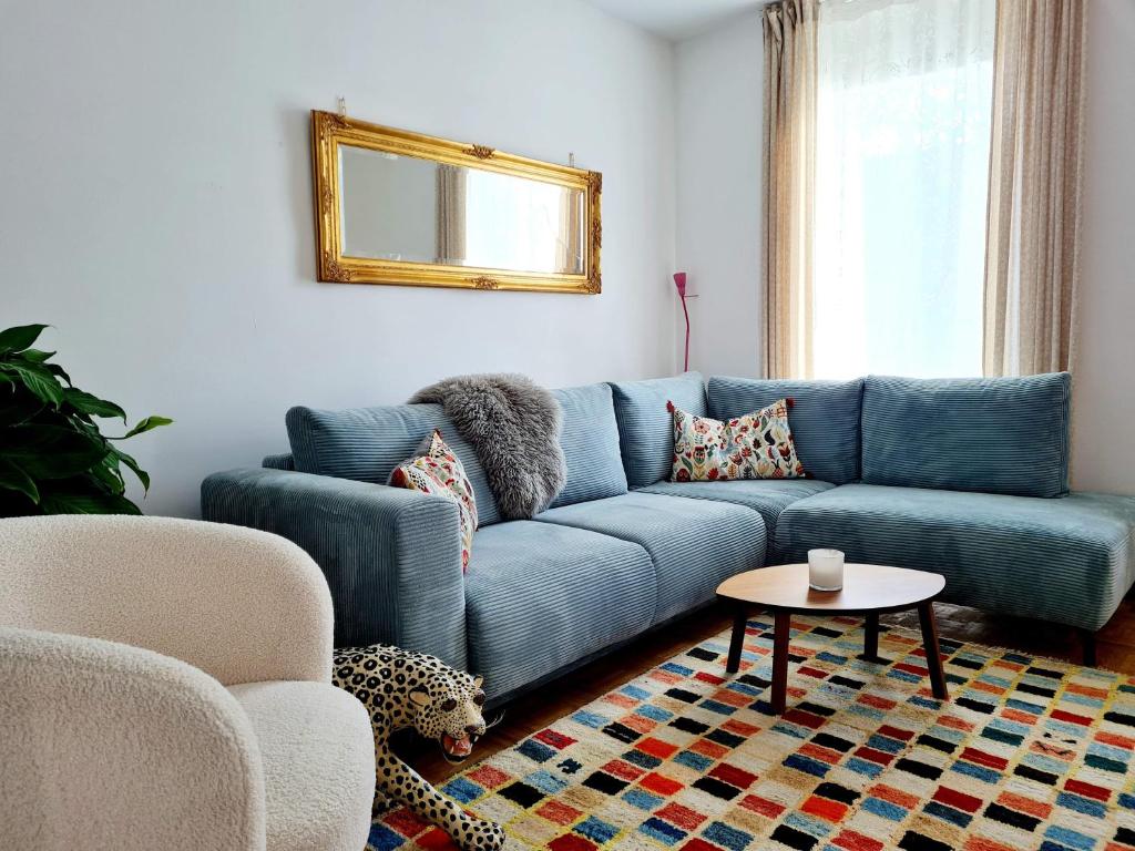 ein blaues Sofa im Wohnzimmer mit einem Tisch in der Unterkunft Best Time In Graz in Graz