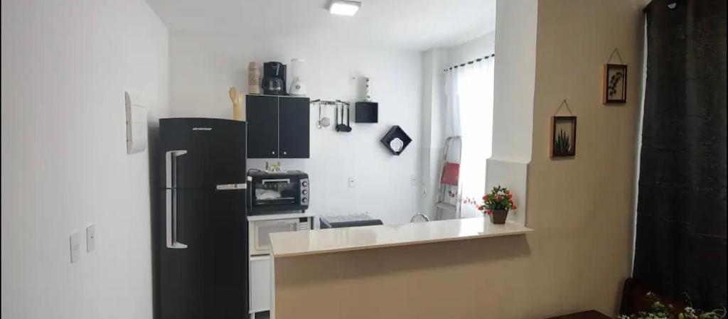 a kitchen with a black refrigerator and a stove at Apartamento exclusivo, próximo a UFMS in Campo Grande