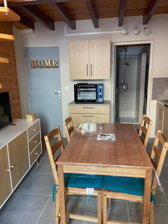 une cuisine avec une table et des chaises en bois dans l'établissement Studio luchon, à Luchon