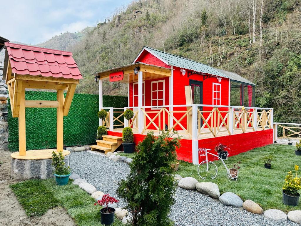 a small red house with a gazebo in a yard at River Land Rize in Ayder Yaylasi