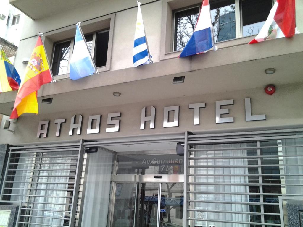 un hôtel arborant des drapeaux à l'avant d'un bâtiment dans l'établissement Hotel Athos, à Buenos Aires