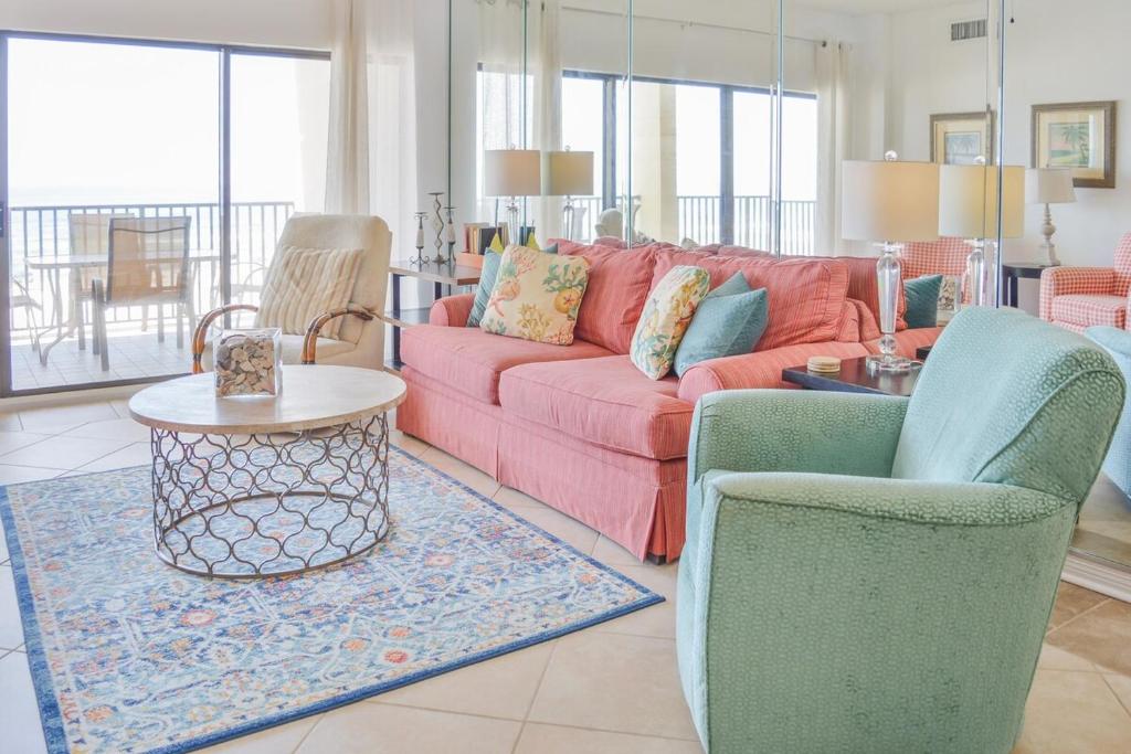a living room with a red couch and two chairs at The Palms 314 in Orange Beach