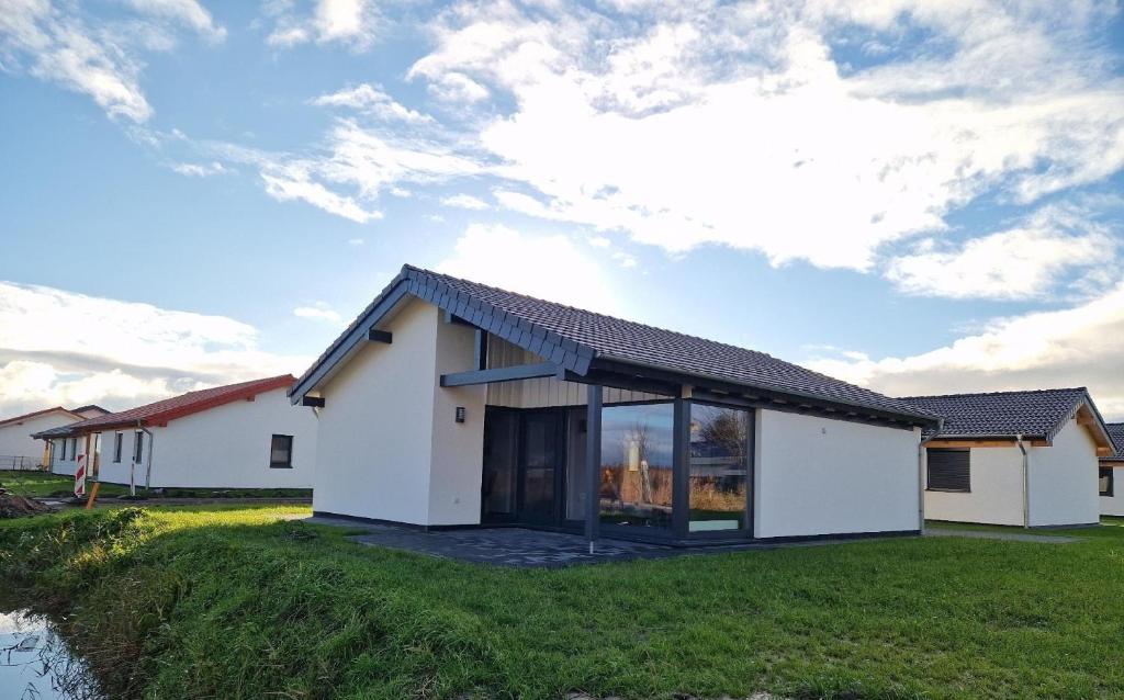 a house with a large window on a grass field at G2 Ferienhaus mit Wiesenblick und Waschmaschine in Großwürden