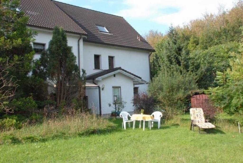 uma casa com uma mesa e cadeiras no quintal em Appartement mit Garten em Werneuchen