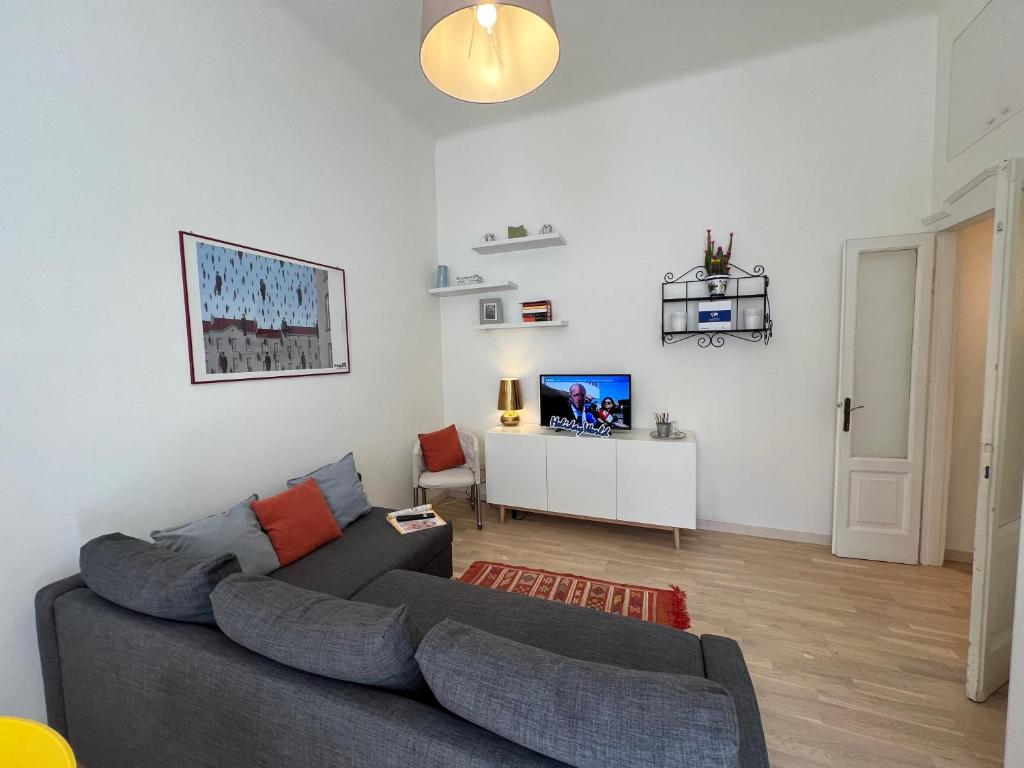 sala de estar con sofá gris y TV en Lotti's House by Holiday World, en Milán