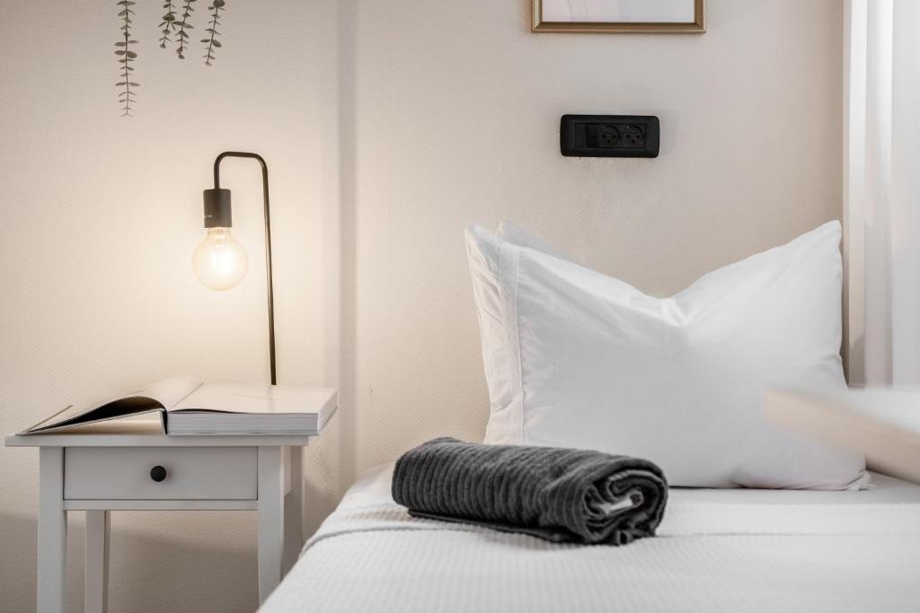 エルサレムにあるthe train studioの白いベッドルーム(壁に時計付きのベッド付)