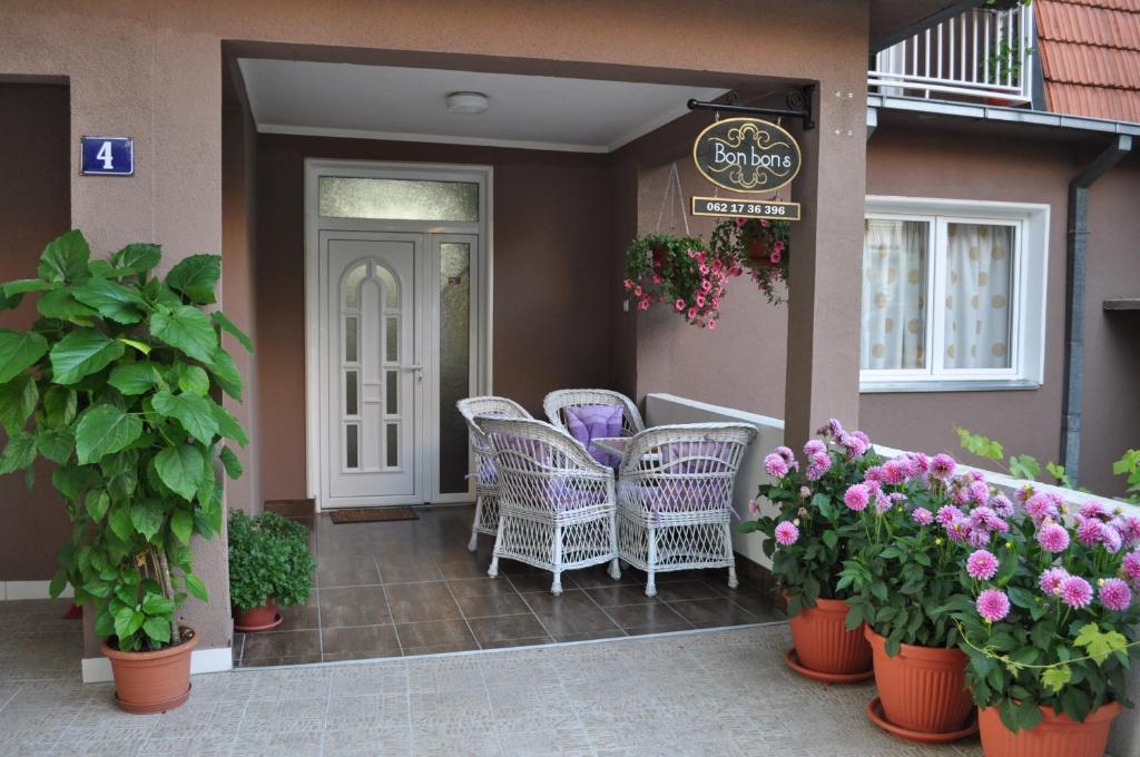 a patio with wicker chairs and flowers on a porch at Apartmani Bon Bons in Soko Banja