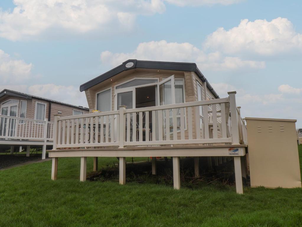 a house with a large deck on the grass at 47 The Drake Forgetmeknot in Scarborough