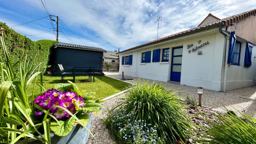 a house with a garden with flowers in the yard at Les Alouettes, maison avec studio pour 4 personnes proche de la baie. in Le Crotoy