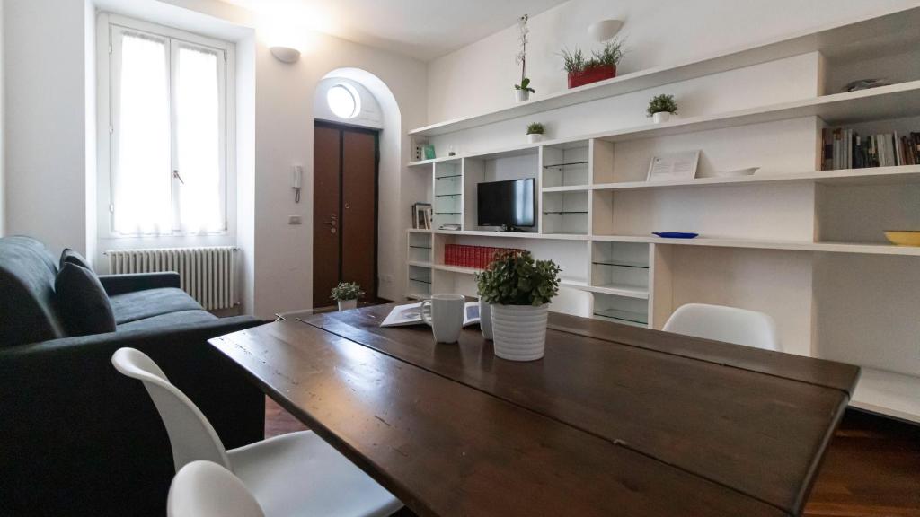 ミラノにあるItalianway-Giulio Romanoのリビングルーム(木製テーブル、白い棚付)